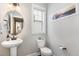 Powder room features a pedestal sink, round mirror, and beach-themed wall art at 562 Boulder Point Dr, Chapel Hill, NC 27516
