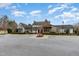 A view of the clubhouse featuring stone and siding with a red door and ample parking at 562 Boulder Point Dr, Chapel Hill, NC 27516