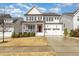 Charming two-story home with white brick, black shutters, a porch and a well-manicured lawn at 562 Boulder Point Dr, Chapel Hill, NC 27516