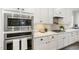 Modern kitchen with stainless steel appliances, gas range, white cabinets, and herringbone backsplash at 562 Boulder Point Dr, Chapel Hill, NC 27516