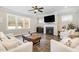 Bright living room with fireplace, ceiling fan, hardwood floors, and large windows at 562 Boulder Point Dr, Chapel Hill, NC 27516