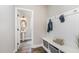 Well-organized mud room with bench, storage baskets, and access to a half bath at 562 Boulder Point Dr, Chapel Hill, NC 27516
