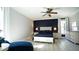 Well-lit bedroom with white furnishings, hardwood floors, and accent wall at 5640 Bella Terra Ct, Wake Forest, NC 27587
