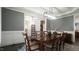 Charming dining room featuring a modern light fixture, decorative wainscoting, and entryway into the living room at 5640 Bella Terra Ct, Wake Forest, NC 27587