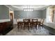 Dining room featuring a gray accent wall, contemporary light fixture, and a dark wood table with seating for six at 5640 Bella Terra Ct, Wake Forest, NC 27587