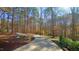 Long driveway leading to a secluded property, bordered by lush greenery and natural rock formations at 5640 Bella Terra Ct, Wake Forest, NC 27587