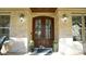 Elegant front entrance with a dark wooden double door, brick siding, and stylish outdoor lighting at 5640 Bella Terra Ct, Wake Forest, NC 27587
