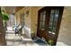 Charming front porch featuring stone flooring, brick siding, a wooden ceiling, and stylish outdoor furniture at 5640 Bella Terra Ct, Wake Forest, NC 27587