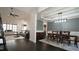 Open-concept living room and dining room featuring a gray sofa, area rug, and dark hardwood floors at 5640 Bella Terra Ct, Wake Forest, NC 27587