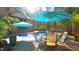 Inviting patio area with a dining set overlooking the pool, surrounded by tropical plants, ideal for outdoor entertaining at 5640 Bella Terra Ct, Wake Forest, NC 27587