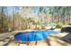 Inviting kidney-shaped pool is surrounded by lush greenery and patio, creating a serene backyard retreat at 5640 Bella Terra Ct, Wake Forest, NC 27587