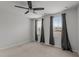 Spacious bedroom with neutral carpet, ceiling fan, and natural light from three windows at 6351 Perry Creek Rd, Raleigh, NC 27616