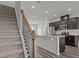 Staircase view of open kitchen featuring stainless appliances, dark cabinetry, granite counters, and an island at 6351 Perry Creek Rd, Raleigh, NC 27616