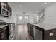Open kitchen with stainless appliances, dark cabinetry, granite counters, and seamless flow to living area at 6351 Perry Creek Rd, Raleigh, NC 27616