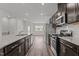 Bright kitchen boasts stainless appliances, dark cabinetry, granite counters, and hardwood flooring at 6351 Perry Creek Rd, Raleigh, NC 27616