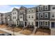 A row of new townhomes showcases diverse exterior colors and designs with landscaped front yards and walkways at 6351 Perry Creek Rd, Raleigh, NC 27616