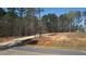 Cleared lot ready for construction with wooded surrounding and a home nearby at 680 Jasmine Rd, Fuquay Varina, NC 27526