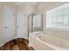 Bright bathroom with a shower, soaking tub, and wood-look flooring at 7 Starwood Ln, Durham, NC 27712