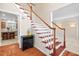 Warm entryway with hardwood floors and staircase offers a glimpse into the kitchen at 7 Starwood Ln, Durham, NC 27712
