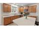 Open kitchen boasts wooden cabinets, granite countertops, stainless steel appliances, and a functional center island at 7 Starwood Ln, Durham, NC 27712