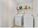Functional laundry room with a washer, dryer, and overhead shelving for storage and organization at 7 Starwood Ln, Durham, NC 27712