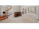 Open-concept living room with staircase, piano, and large windows for natural light at 7 Starwood Ln, Durham, NC 27712