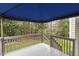 Wooden back deck with a blue canvas awning, surrounded by lush trees at 733 Hillsford Ln, Apex, NC 27502