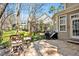 Stone patio features a built-in grill and outdoor seating, overlooking the lush backyard at 81517 Alexander, Chapel Hill, NC 27517