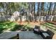 Backyard with patio, wooded perimeter, and outdoor seating surrounded by mature trees at 8612 Keegan Ct, Raleigh, NC 27613