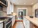 Kitchen with stainless steel appliances, tile backsplash, island with butcher block top, and hardwood flooring at 914 Dorothea Dr, Raleigh, NC 27603