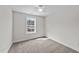 Sunlit bedroom featuring neutral walls, carpet floors, and a large window with a peaceful view at 1019 Thompson Rd, Four Oaks, NC 27524