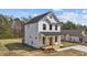 Two-story home with black framed windows, front porch, white siding and stone accents at 1019 Thompson Rd, Four Oaks, NC 27524