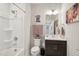 Bright bathroom featuring a shower-tub combo, decorative art, and a dark vanity, creating a functional and stylish space at 10320 Sablewood Dr # 107, Raleigh, NC 27617