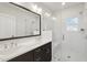 Modern bathroom with a double sink vanity, dark cabinets and a glass enclosed shower with a built-in seat at 10320 Sablewood Dr # 107, Raleigh, NC 27617