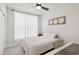 Bright bedroom with neutral decor, a ceiling fan, white curtains, and an accent table, creating a relaxing space at 10320 Sablewood Dr # 107, Raleigh, NC 27617