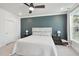 Comfortable bedroom with an accent wall, neutral carpet, ceiling fan, and matching nightstands at 10320 Sablewood Dr # 107, Raleigh, NC 27617