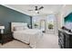 Inviting bedroom featuring an accent wall, ceiling fan, large windows, and a comfortable queen bed at 10320 Sablewood Dr # 107, Raleigh, NC 27617