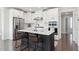 Stylish kitchen boasts white cabinets, a stainless steel refrigerator, a dark island with seating, and modern appliances at 10320 Sablewood Dr # 107, Raleigh, NC 27617