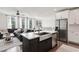 Open concept featuring kitchen with stainless appliances and living area with large windows and dark sectional at 10320 Sablewood Dr # 107, Raleigh, NC 27617