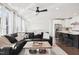 Open-concept living space featuring a comfortable sectional, ceiling fan, and a view into the modern kitchen at 10320 Sablewood Dr # 107, Raleigh, NC 27617