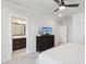 Main bedroom featuring an ensuite bathroom, ceiling fan, and a dark wood dresser with a television on top at 10320 Sablewood Dr # 107, Raleigh, NC 27617