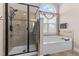 Bright bathroom featuring a glass-enclosed shower, a soaking tub under a large arched window, and neutral tile at 1046 Lawrence Rd, Wake Forest, NC 27587