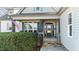 Inviting front porch with stone accents, a welcome sign, and American flag at 1046 Lawrence Rd, Wake Forest, NC 27587
