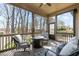 Relaxing screened porch with comfortable seating, fire pit, views of mature trees, and outdoor speaker at 1046 Lawrence Rd, Wake Forest, NC 27587