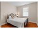 Cozy bedroom features a full bed with decorative pillow, a wrought iron frame, and a window with blinds at 10511 Rosegate Ct # 203, Raleigh, NC 27617