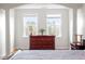 Bright bedroom features two large windows, a dark wood dresser, and decorative columns framing the entrance at 10511 Rosegate Ct # 203, Raleigh, NC 27617