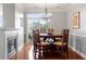 Cozy dining area featuring a fireplace, chandelier, large window, and ample seating with a full dining set at 10511 Rosegate Ct # 203, Raleigh, NC 27617