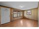 Cozy living room with wood paneled walls, wood-look laminate floors, and a door and window at 107 Rencher St, Hillsborough, NC 27278