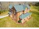 Aerial view of brick home with green roof and covered porch with landscaping at 1100 Reatkin Ln, Graham, NC 27253