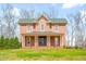 Inviting red brick home with a covered porch and classic architectural details at 1100 Reatkin Ln, Graham, NC 27253